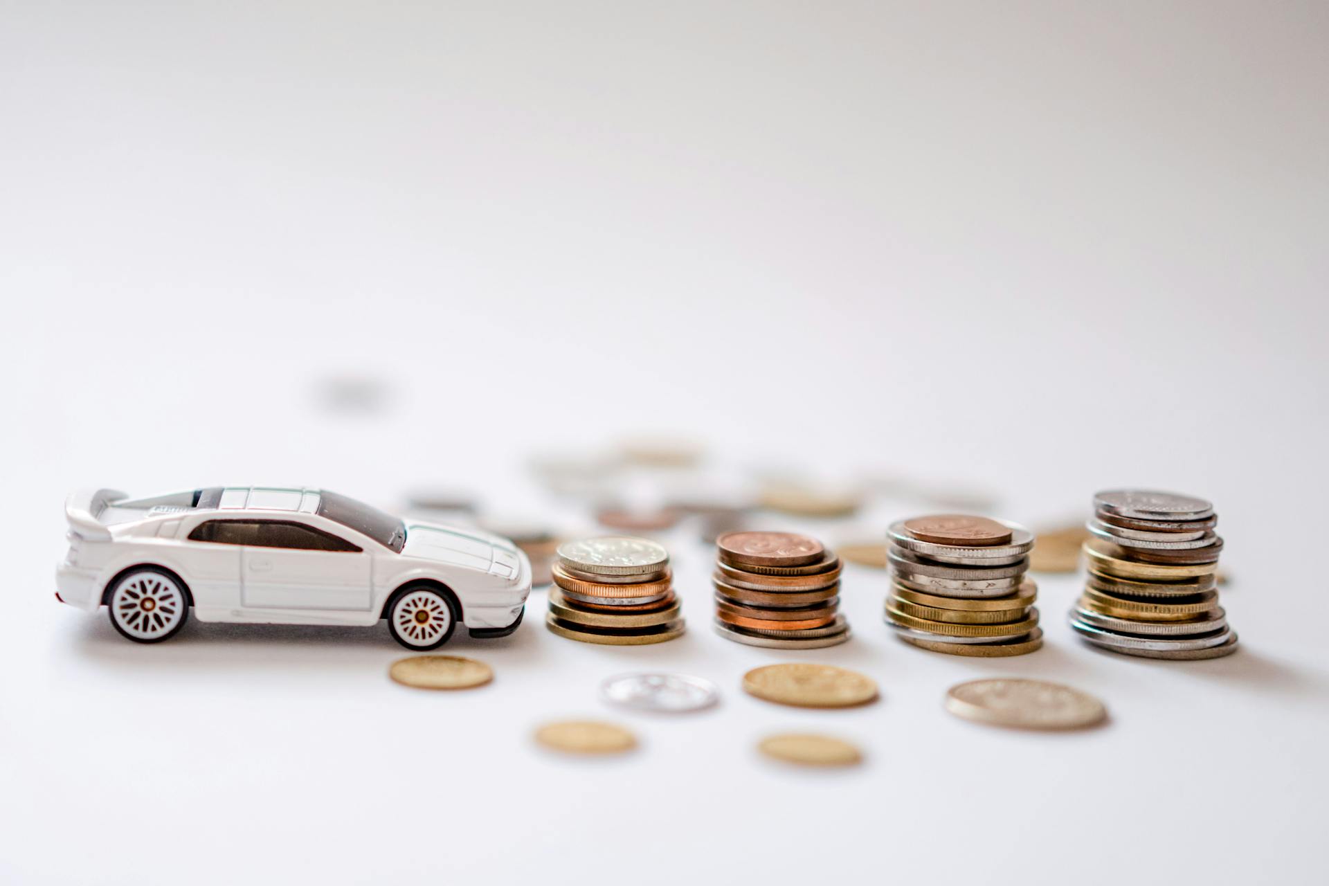Toy car beside stacks of coins illustrating auto financing